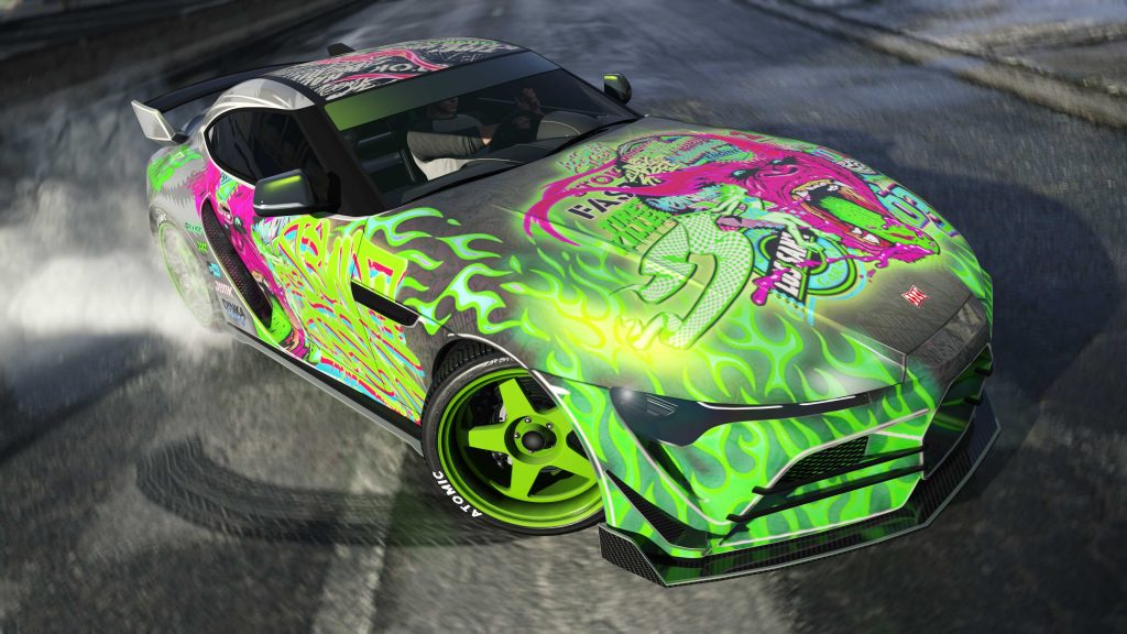 GTA Online screenshot of the Dinka Jester RR sports car in the Drift Gorilla Green livery. The car is on a drift course. The livery is bright green, pink, black, and white with a large monster on the hood. The Jester RR has green wheels with Atomic branding on the tires. The front of the car and side of the car are visible with the headlights on.