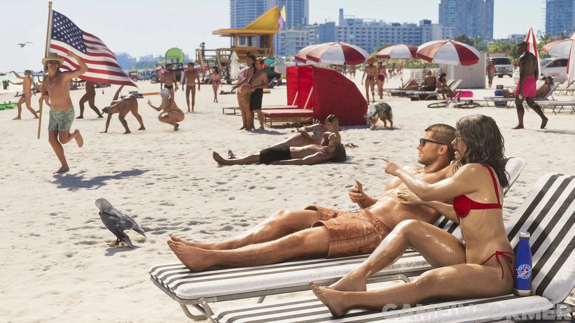 Grand Theft Auto VI protagonists Lucia and Jason relaxing on striped lounge chairs at a crowded Vice City beach, featuring a man running with an American flag, sunbathing NPCs, beach umbrellas, and city buildings in the background.