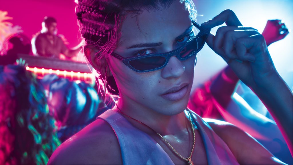 Lucia wearing a white tank top and gold chain looking at the camera and lifting her dark sunglasses in a club with pink and blue neon lights in GTA VI.
